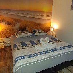 Comfortabele slaapkamer in Gastvrij vakantiehuis Den Burg, Texel, met strandthema voor een rustgevende nachtrust.