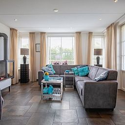 Villa Magnifique, Den Burg, Texel: modernes Wohnzimmer mit gemuetlicher Sitzecke und viel Tageslicht.