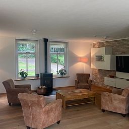 Cozy living room of Cottage in Den Burg, Texel with comfortable seating area and large windows.