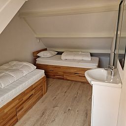 Gemuetliches Schlafzimmer mit zwei Einzelbetten im Ferienhaus Kogerstraat, Den Burg, Texel. Perfekt fuer einen Familienaufenthalt.