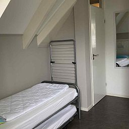 Schlafzimmer im Ferienhaus NH197 Texel mit bequemem Bett und Holztisch