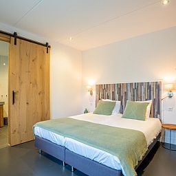 Komfortables Schlafzimmer mit eigenem Bad in der Gruppenunterkunft Nieuw Leven 36p, Den Burg, Texel.