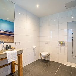 Stilvolles Badezimmer mit begehbarer Dusche in der Gruppenunterkunft Nieuw Leven 36p, Ferienhaus auf Texel.