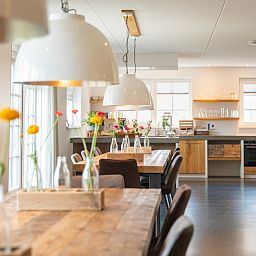 Gemuetlicher Essbereich mit Holztischen in der Gruppenunterkunft Nieuw Leven 36p, Den Burg, Texel.