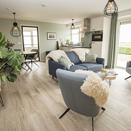 Ruime woonkamer van Onder de Wol vakantiehuis Texel met uitzicht op de natuur.
