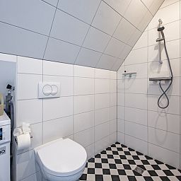 Bathroom with washing machine in Hotel Loodsmans Welvaren - Apartment, Den Hoorn, Texel.