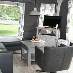 Gemuetliche Sitzecke im Caravan Rust & Ruimte, Den Hoorn, Texel, mit bequemem Sofa und Fernseher.