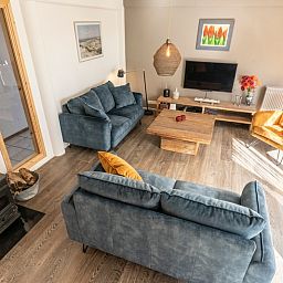 Uebersicht des Wohnzimmers im Ferienhaus Sil, Den Hoorn, Texel mit Sitzecke und Holzboden.