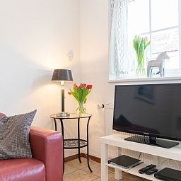 Gemuetliche Ecke im Rabbit Hole Texel mit Fernseher und stimmungsvoller Dekoration.