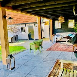 Cozy veranda at Holiday home in Oosterend, Texel, with comfortable seating and views of the garden.