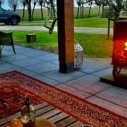 Cozy terrace with fireplace at Holiday home in Oosterend, Texel, ideal for evenings in nature.
