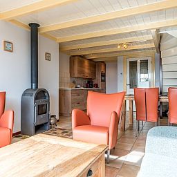 Innenansicht des Ferienhauses in Oosterend, Texel, Ferienhaus mit Holzofen und bequemen Stuehlen auf den Watteninseln.