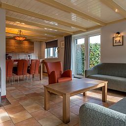 Open living space in Holiday home in Oosterend, Texel, with wood stove and dining area.