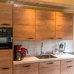 Modern kitchen in Holiday home in Oosterend, Texel, with wooden cabinets and appliances.