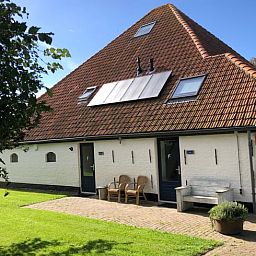 Front of Holiday home in Oosterend, Texel with sitting area. Charming vacation home on the Wadden Islands.