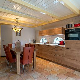 Dining room and kitchen in Zilverling vacation home, Oosterend, Texel with wooden furniture.