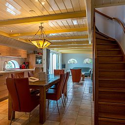 Spacious dining room with wooden stairs in Zilverling vacation home in Oosterend, Texel.