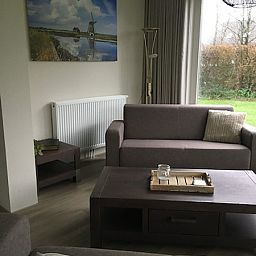 Modern sitting area in vacation home Vuurtoren, Oosterend, Texel with art on the wall.