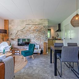 Stylish dining area and open kitchen in vacation home Bungalowpark De Toes - Zeewier, Oosterend, Texel, ideal for family dinners.