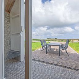 Terrasse von Cottage in Oudeschild, Ferienhaus auf Texel, mit schoener Aussicht auf die Felder.