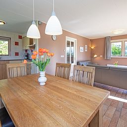 Eethoek in 8690 - Junier - Huisman vakantiehuis, Zuid-Eierland, Texel, met houten tafel en uitzicht op de natuur.