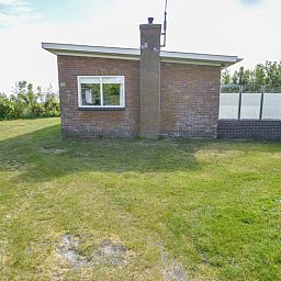 Vooraanzicht van Slufterbungalows 362 in Bungalowpark Slufteroord, Texel met ruime grasvelden.