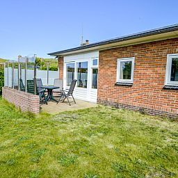 Veranda van Slufterbungalows 362 in Bungalowpark Slufteroord, Texel met zitgelegenheid en groen uitzicht.