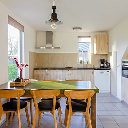 Dining area in De Triaan vacation homes, Zuid-Eierland, Texel, with spacious table and lots of natural light.