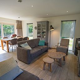Heller Wohnbereich im Ferienhaus de Parel 150, De Dennen, Texel mit Blick auf den Garten.