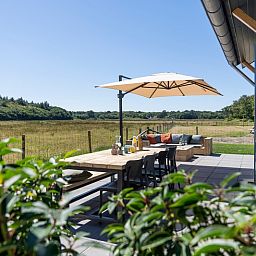 Terrace of Holiday Home 2 in De Dennen, Texel with views of nature and comfortable seating.