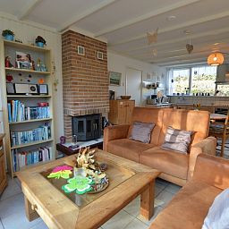 Vakantiehuis de Parel 212 in De Dennen, Texel met sfeervolle open haard en boekenplank.