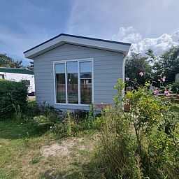 Vorderseite von Vakantiepark de Bremakker - Bosveld 135, Ferienhaus in De Dennen, Texel mit bluehendem Garten.