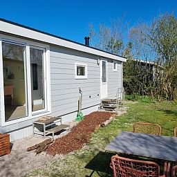 Seitenansicht von Vakantiepark de Bremakker - Bosveld 135, Ferienhaus in De Dennen, Texel mit Terrasse und Gartenmoebeln.
