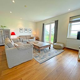 Stijlvolle zithoek in Appartement Bos en Duin 40, De Dennen, Texel, met houten vloer en moderne inrichting.