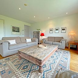 Ruime woonkamer van Appartement Bos en Duin 40, Texel, met rustieke houten tafel en sfeervolle verlichting.