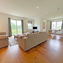 Open woonruimte van Appartement Bos en Duin 40 in De Dennen, Texel, met eetgedeelte en uitzicht op de groene omgeving.