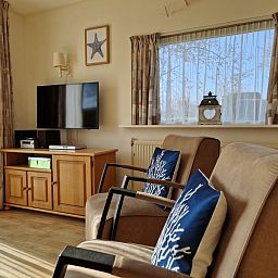 Comfortable sitting area with television in Bungalowpark Uterste Coogh - Bungalow 116, De Dennen, Texel for relaxation.