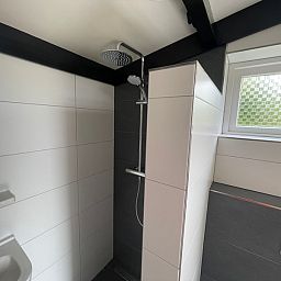 Walk-in shower in the bathroom of Wollewei vacation home, De Dennen, Texel.