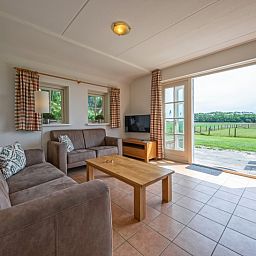 Cozy living room of 't Mienthuis - De Jonker, vacation home in De Dennen, Texel with beautiful views of the nature of the Wadden Islands.