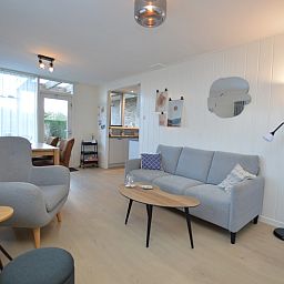 Gemuetliches Wohnzimmer im Bungalow Uterste Coogh 104, De Dennen, Texel, mit bequemer Sitzecke.
