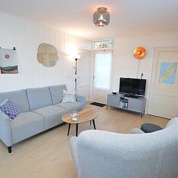 Stilvoller Wohnbereich im Ferienhaus Uterste Coogh 104, Texel, mit bequemem Sofa und Sessel.