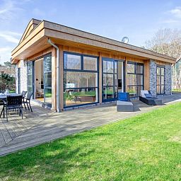 Vakantiehuis De Vlinder in Bungalowpark 't Hoogelandt op Texel biedt een ruim terras met zitgelegenheid in de natuurlijke omgeving van De Dennen.