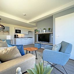 Ruime woonruimte in Appartement Bos en Duin 30, De Dennen, Texel met moderne keuken en comfortabele zithoek.