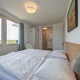 Schlafzimmer mit Doppelbett in Cottage 6, De Dennen, Texel, mit Blick auf die Natur.
