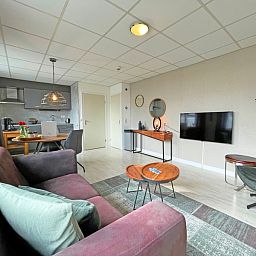 Offene Kueche und Wohnzimmer im Appartement Bos en Duin 25, Texel mit moderner Ausstattung.