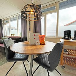 Essecke am Fenster im Apartment Bos en Duin 25, De Dennen, Texel mit Blick auf die Umgebung.