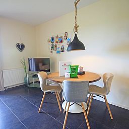 Eetgedeelte in Appartement Bos en Duin 42, Texel met ronde tafel en moderne stoelen voor gezellige maaltijden.