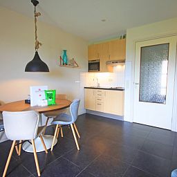 Open keuken in Appartement Bos en Duin 42, De Dennen, Texel met eethoek en praktische voorzieningen.