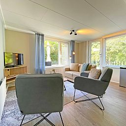 Dining area in Apartment Bos en Duin 22, De Dennen, Texel with wooden table and stylish chairs.