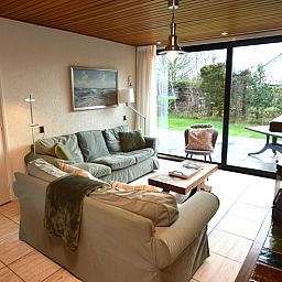 Cozy living room in Holiday home de Parel 258, Texel, overlooking the garden.
